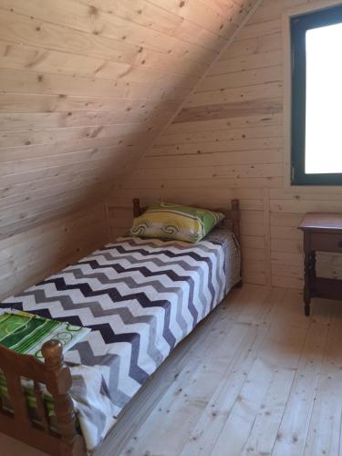 a bedroom with a bed in a log cabin at Vikendica Jovičić 2 in Bogutovac