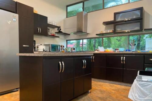 a kitchen with black cabinets and a large window at Casa Vacacional para Familias en Villavicencio in Villavicencio
