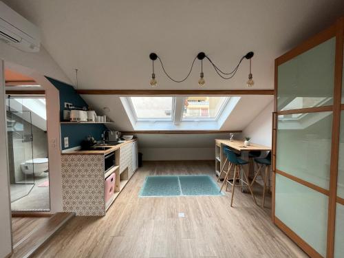 - une cuisine mansardée avec un évier et une table dans l'établissement Au petit Marius, à Cannes