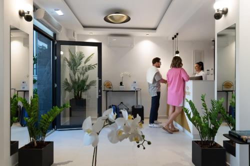Ein Mann und eine Frau stehen in einer Küche in einem Haus in der Unterkunft Melite Luxury Rooms & Apartments in Paliouri