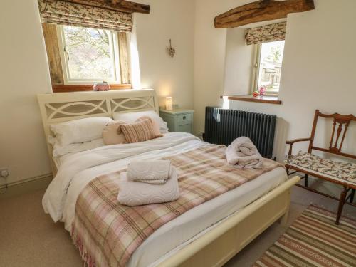 a bedroom with a large bed with towels on it at Litton Hall Barn Cottage in Skipton