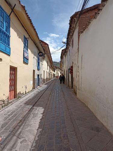 an alley with people walking down a street at Hostal Killaly Inn Cusco in Cusco