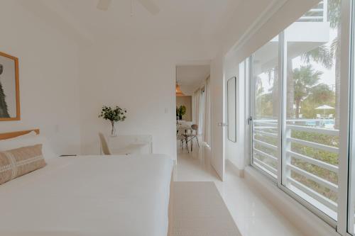 a bedroom with a white bed and a large window at Lumina at Palms Punta Cana Village in Punta Cana