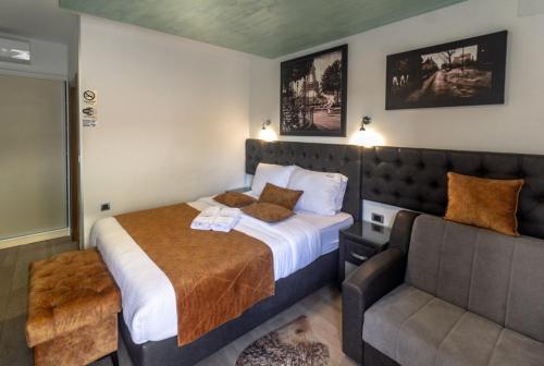 Habitación de hotel con cama y sofá en Motel Atos Bungalovi en Nova Topola