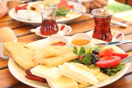 a plate of food with cheese and vegetables on a table at Selin Otel Belek in Antalya