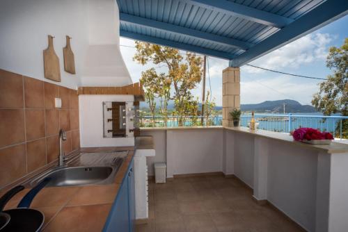 cocina con techos azules y vistas al agua en Villa Salomon BY APOKORONAS-VILLAS, en Plaka