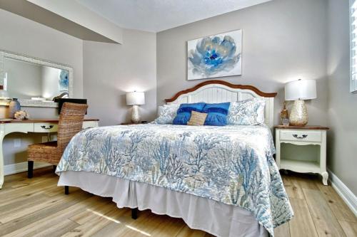 a bedroom with a bed with a blue and white bedspread at On The Rocks 1 in Clearwater Beach