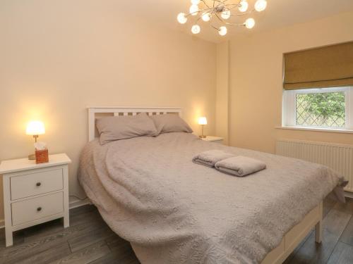 a bedroom with a bed with two pillows on it at 10 West Cottages in Oldham