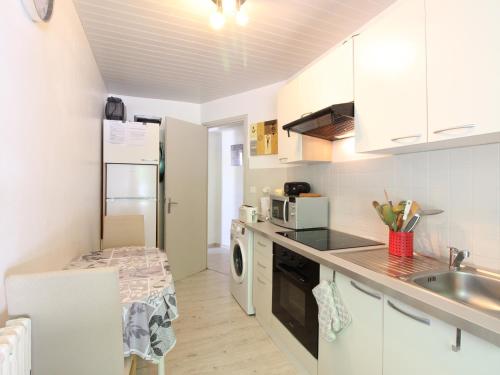 une cuisine avec un évier et un plan de travail dans l'établissement T2 cosy avec jardin, proche centre, chien accepté - FR-1-608-59, à Le Mont-Dore