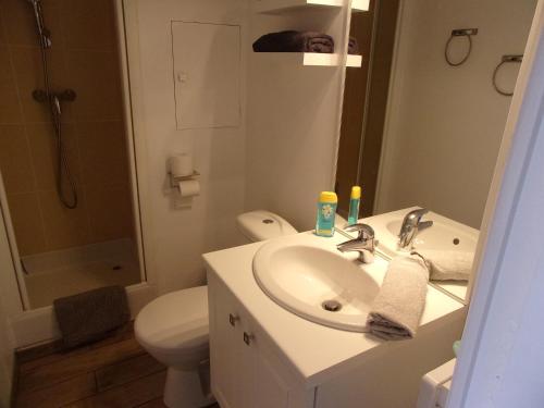a white bathroom with a sink and a toilet at Le Bain de mer, Studio à la plage, Pleneuf in Le Val-André