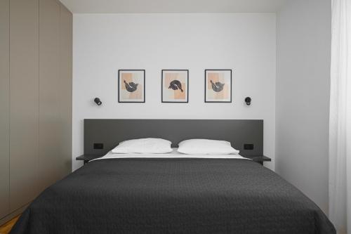 シベニクにあるHoliday home Villa Portaのベッドルーム1室(壁に3枚の写真が飾られたベッド1台付)