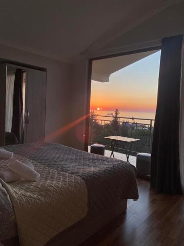 a bedroom with a bed and a view of the sunset at Iberia 2019 in Batumi