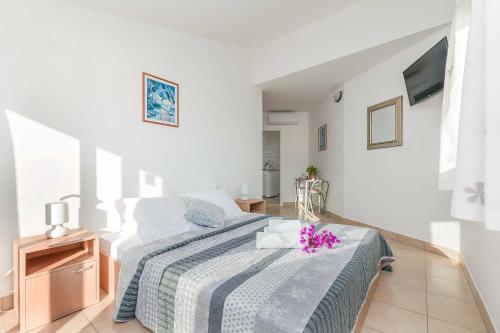 een slaapkamer met een bed met een blauwe en witte deken bij Apartmani Neno in Lokva Rogoznica