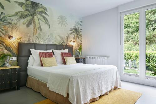 a bedroom with a large bed with white sheets at Hotel Boutique Txanka Erreka PARKING INCLUIDO in Orio