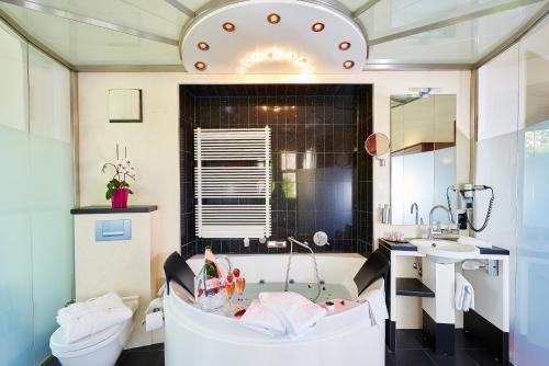 a bathroom with a tub and a toilet and a sink at Villa Boutique Hotel in Straubing