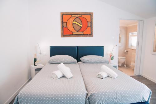 a bedroom with a bed with two pillows on it at Hotel Aurora & Appartamenti in Nago-Torbole