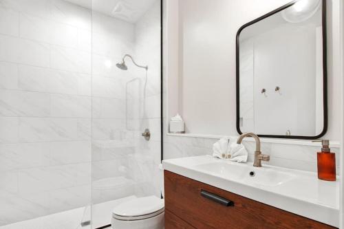a white bathroom with a sink and a shower at Fab 1838 Garden District 5BR with Parking And Balcony in New Orleans