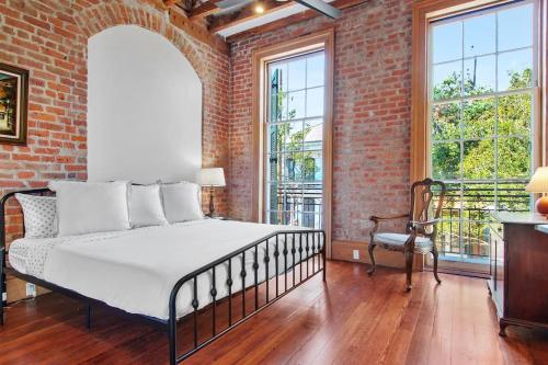 a bedroom with a bed and a brick wall at Fab 1838 Garden District 5BR with Parking And Balcony in New Orleans