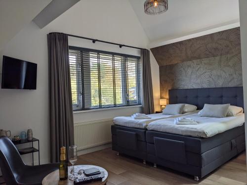 ein Schlafzimmer mit einem blauen Bett und einem großen Fenster in der Unterkunft Bed&Bubbels 256 in De Koog