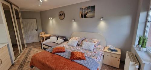 a bedroom with a bed with pillows and a chair at Apartamenty Hexagon nr 25 in Grzybowo