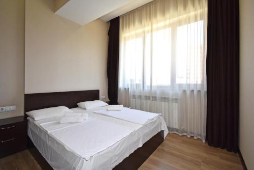 a bedroom with a bed and a large window at Residence North Avenue, Teryan 8. 14 2 in Yerevan