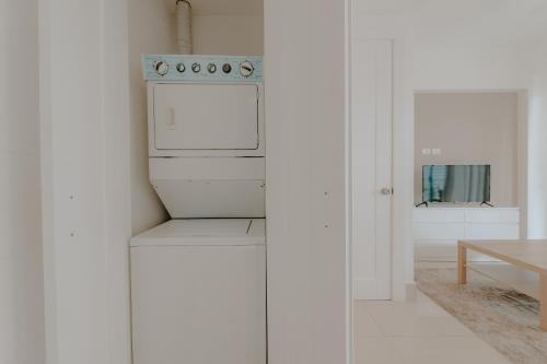 een witte keuken met een fornuis en een tafel bij Lumina at Palms Punta Cana Village in Punta Cana