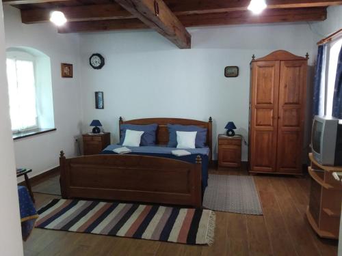 1 dormitorio con 1 cama y TV. en Helesfa Vendégház en Helesfa