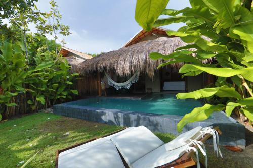 a resort with a swimming pool next to a building at Pousada Tatuá in Pôrto de Pedras