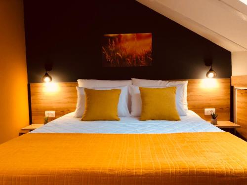 - une chambre avec un grand lit et 2 oreillers jaunes dans l'établissement Urban Corner - Deluxe Apartments, à Bitola