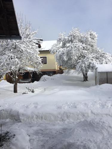 a yard covered in snow next to a house at Ferienwohnung Morgensonne in Mühlen