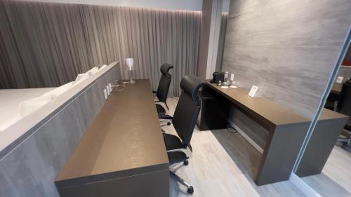 an office with two desks and chairs in a room at Intercity Campina Grande Citymix in Campina Grande