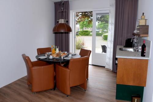 een eetkamer met een tafel en stoelen en een keuken bij Bed and Breakfast in de buurt in Waalwijk
