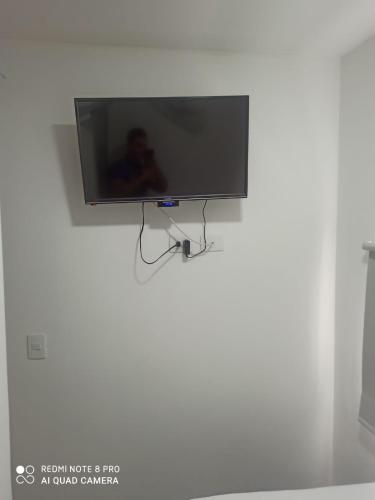 a flat screen tv hanging on a white wall at Hotel zona express sandiego in Medellín