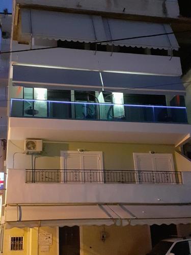 a white building with a balcony and lights on it at Ngjela Apartments in Sarandë