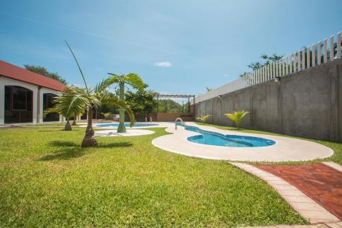 a backyard with a swimming pool in the grass at KO'OLEBIL in Boca del cielo