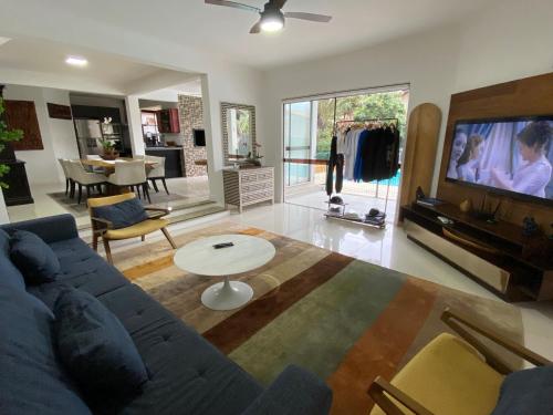 uma sala de estar com um sofá azul e uma televisão em Pousada Casa da Praia em São Francisco do Sul