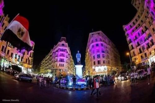 a city at night with purple lights on the buildings at One Season Hotel in Cairo