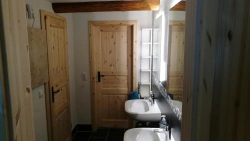 a bathroom with two sinks and a mirror at Historisches Ferienhaus "Schwalbennest" mit Eseln in Holzhausen