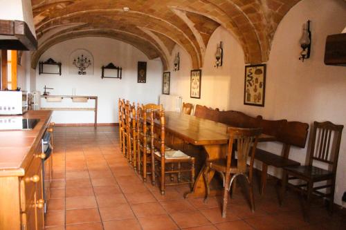 cocina y comedor con mesa de madera y sillas en Mas Goy, casa rural con piscina, en Girona