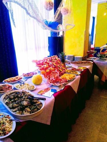 a table with many plates of food on it at Hotel Arabesco in Rimini