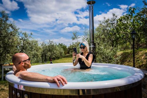a man taking a picture of a woman in a hot tub at Casa Montalgallo in Lucignano