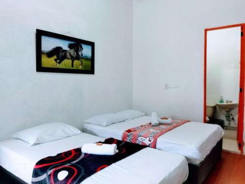 a room with two beds and a picture of a horse on the wall at Jardín es Tuyo in Jardin