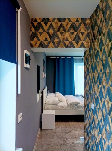 a bedroom with a bed and a blue curtain at BALTĀ māja in Aglona