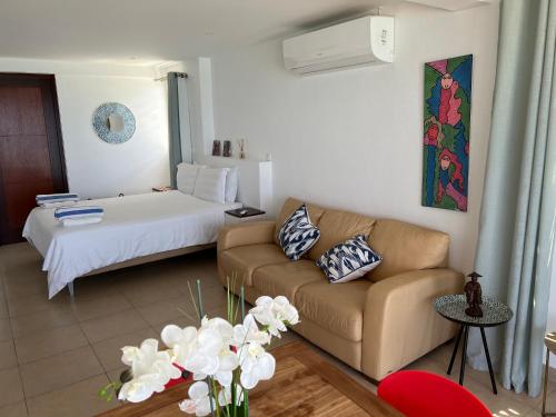 ein Wohnzimmer mit Sofa und Bett in der Unterkunft GRAND VIEW Luxury water front studio at Grand Case in Grand Case