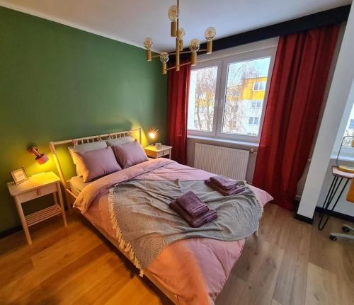 a bedroom with a large bed with red curtains at Uroczy apartament blisko centrum - 10 min do plaży in Gdynia