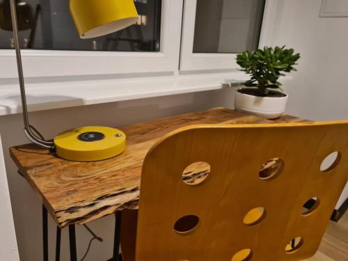 uma mesa de madeira com uma lâmpada e uma planta sobre ela em Uroczy apartament blisko centrum - 10 min do plaży em Gdynia