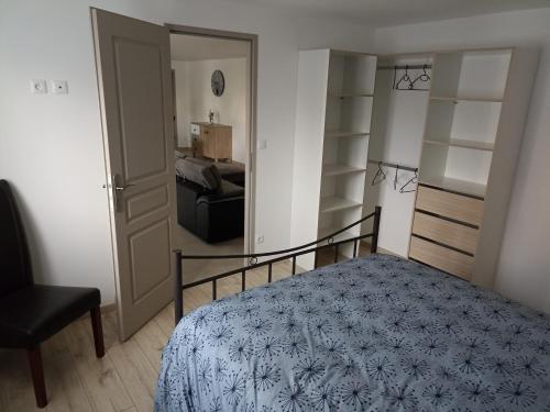- une chambre avec un lit et une porte menant à une pièce dans l'établissement Le LuMille, à Allenay