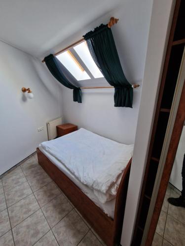 a small bedroom with a bed and a window at Apartament Hexagon nr 36 in Grzybowo