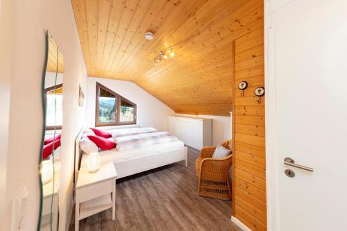 een slaapkamer in een tiny house met een bed en een bureau bij Ferienwohnung im Alpenblick in Steinen