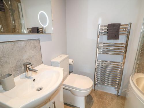 une salle de bain avec des toilettes blanches et un lavabo dans l'établissement Beachcomber, à Ballycastle